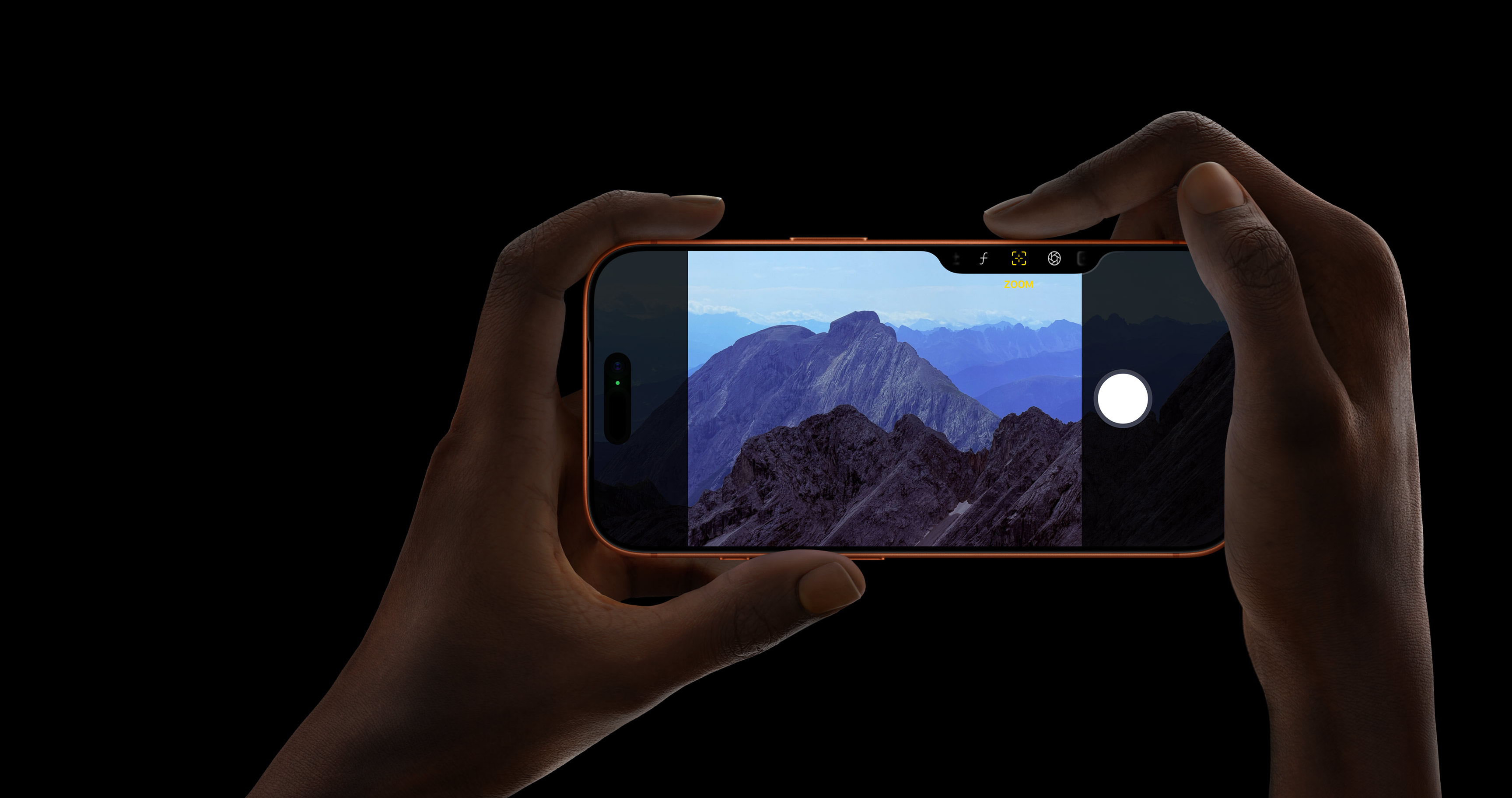 Рука держит iPhone 17 Pro в цвете Cosmic Orange во время съёмки гор