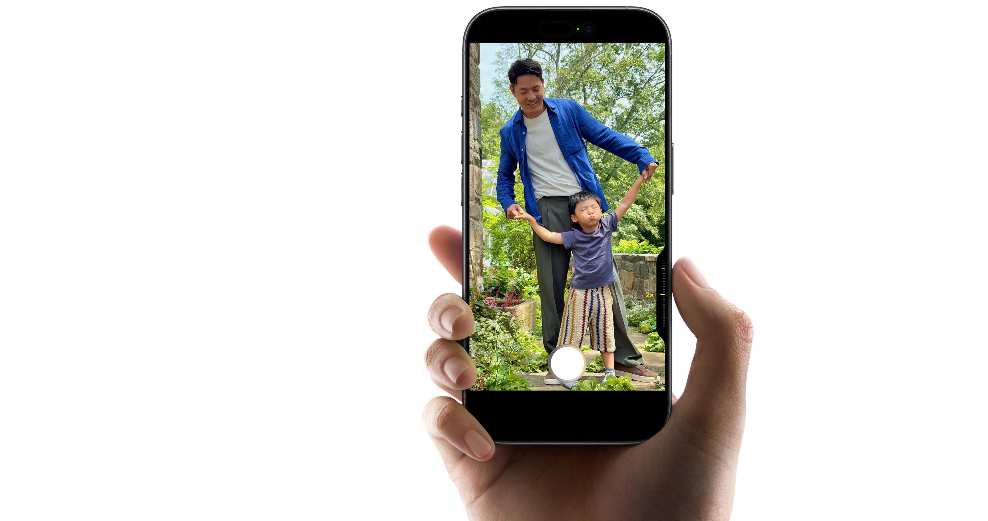 iPhone 17 в руке снимает отца с ребёнком с двукратным увеличением