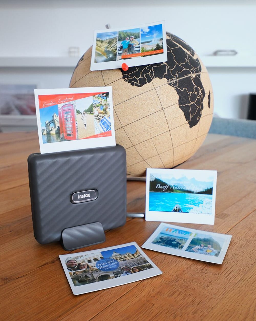 Фотопринтер Fujifilm Instax Link Wide печатает коллажи из путешествий рядом с глобусом