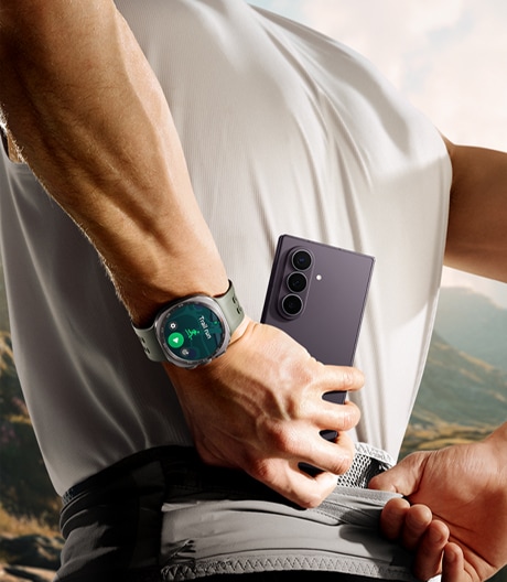 Galaxy Z Fold8 Ultra с тройной камерой в руке рядом с умными часами во время тренировки